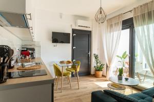 a kitchen and living room with a couch and a table at Mare Blue The Vintage Suite in Skala Rachoniou