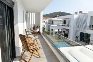 an apartment balcony with chairs and a swimming pool at Mare Blue The Vintage Suite in Skala Rachoniou