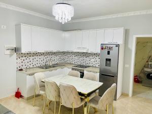 a kitchen with a table and chairs and a refrigerator at Albi guests House Tirana in Tirana