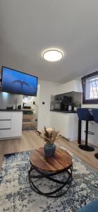 ein Wohnzimmer mit einem Tisch und einem Flachbildfernseher in der Unterkunft Le superbe in Allinges + 2 Fotos