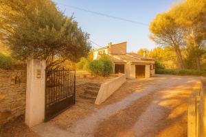 a house with a gate in front of a driveway at Les Mûriers in La Ciotat