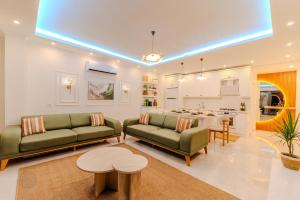 ein Wohnzimmer mit 2 grünen Sofas und einem Tisch in der Unterkunft Holidays are the best days, villa vacation is great in Çavdır