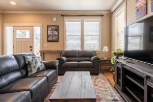 Una sala de estar con un sofá de cuero y una mesa. en Garfield 2BR - New Build - Foodie-Friendly Stay, en Portland