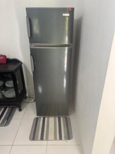 a stainless steel refrigerator in a corner of a kitchen at June’s comfort paradise in Runaway Bay
