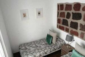 a small room with a bed with a stone wall at Casas Galloway - Anaga Misteriosa y mágica in El Bailadero