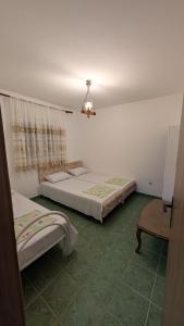 a bedroom with two beds and a chandelier at Private guest-house Gutic in Sutomore