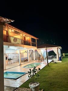 ein Haus mit Pool im Hof in der Nacht in der Unterkunft Sítio Cantinho da Roça Perobas in Paraju