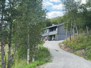 a house on a hill with a gravel road at Bjørkli Lodge in Geilo
