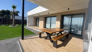 ein Holztisch und eine Bank auf dem Balkon eines Hauses in der Unterkunft Villas de lujo con Chimenea y Vistas Panorámicas a la Sierra de Cazorla in Pozo Alcón