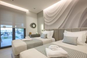 a bedroom with two beds with white pillows at Thea Suites in Ouranoupoli +54 photos