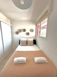 Un dormitorio con dos camas y una ventana. en Superbe 4 couchages avec terrasse - Clim - 50m de la mer, en Saint-Raphaël