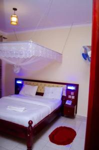 KarengaにあるKidepo Adere Lodgeの赤いラグが敷かれた大きなベッドのある寝室