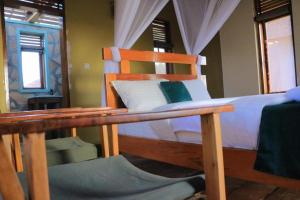 KarengaにあるKidepo Adere Lodgeのベッドルーム(木製ベッド1台、テーブル付)