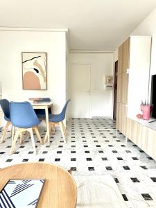 una sala de estar con una mesa y sillas en Superbe 4 couchages avec terrasse - Clim - 50m de la mer, en Saint-Raphaël