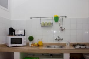 a kitchen counter with a microwave and a plate of fruit at Apartamentos Calypso in Punta Umbría