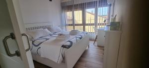 a white bed in a room with a window at Apartamentos Les Texuques in Nueva de Llanes