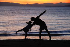 un hombre y una mujer bailando en la playa al atardecer en Hibiscus Garden, en Santa Catalina