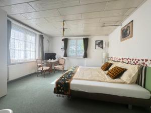 ein Schlafzimmer mit einem Bett und einem Tisch und Stühlen in der Unterkunft Seehotel Schwert in Gersau