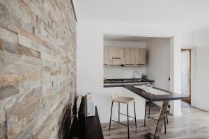 a kitchen with a brick wall and a table and chairs at Borgo Antico in Sappada
