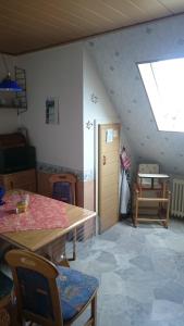 Zimmer im Dachgeschoss mit einem Tisch und einem Fenster in der Unterkunft FeWo Franssen in Dornumersiel