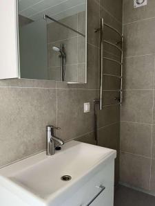 a bathroom with a sink and a shower with a mirror at Stormur Cottages in Vallanes +24 photos
