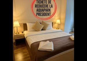 a bedroom with a bed with a sign on the wall at Mid Velvet Apartment, Free Parking, Self Check-in in Oradea