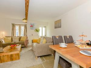 a living room with a couch and a table at Whibberley Cottage in Ashford