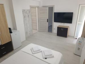 een witte woonkamer met een tv en een bank bij Max Night Dreams in Boekarest +39 foto's
