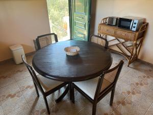 a dining room table with chairs and a microwave at TETRAKTYS ESTATE sea view beachside 3 bedrooms Αήρ in Halikounas