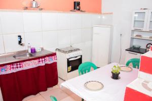 a small kitchen with a table and a stove at Hostel da Lua in Barreirinhas