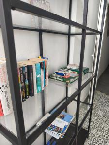ein schwarzes Bücherregal mit Büchern drauf in der Unterkunft Center Flat Puerto Del Carmen near the Beach NATURAL ELEMENTS APARTMENT in Puerto del Carmen + 24 Fotos