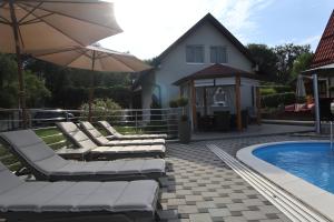 a group of lounge chairs next to a swimming pool at Kuća za odmor Tina in Gladovec Pokupski