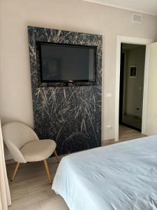 a bedroom with a bed and a tv on a wall at Ales apartment in Cuneo +14 photos