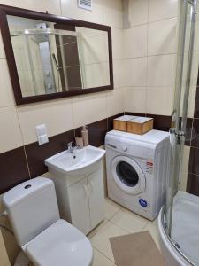 a bathroom with a toilet sink and a washing machine at Apartament Premium Tarnów 2 in Tarnów +5 photos