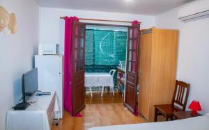 a room with a desk with a computer and a refrigerator at Studio privé climatisé en bas de villa in Fort-de-France
