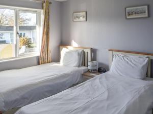 two beds sitting next to each other in a room at Alula Lodge in Lowestoft +3 photos