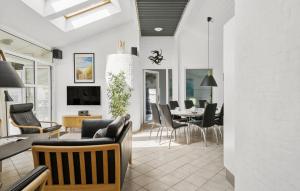 a dining room and living room with a dining table at Stunning Home In Blokhus With Sauna in Blokhus