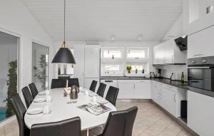 a kitchen and dining room with a white table and chairs at Stunning Home In Blokhus With Sauna in Blokhus