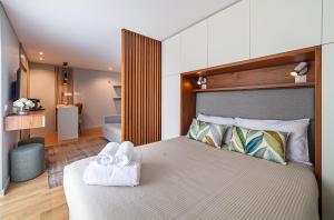 a bedroom with a large bed with towels on it at Seagull Lodge incl Parking by Home Sweet Home Aveiro in Aveiro