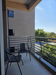 two chairs sitting on a balcony with a view at Marmen Apart-Dpto en CDE in Ciudad del Este