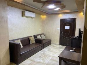 Una sala de estar con un sofá y una mesa y una puerta. en Siveen Hotel, en Amán