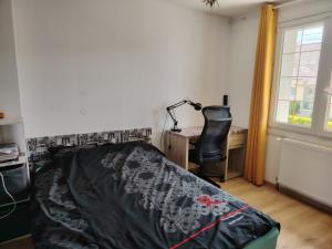 Un dormitorio con una cama, un escritorio y una silla. en appartement étage, en Brest