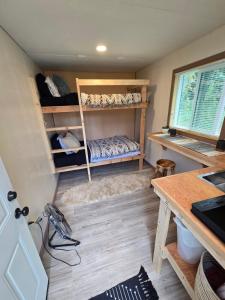 a room with a bunk bed and a desk at Highway HotTub Hideaway Bunkbed sleeps two in Tok