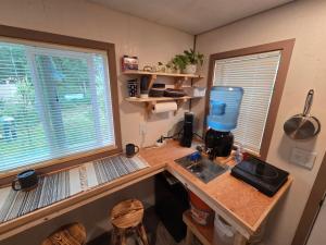 a kitchen with a counter with a mixer and two windows at Highway HotTub Hideaway Bunkbed sleeps two in Tok +2 photos