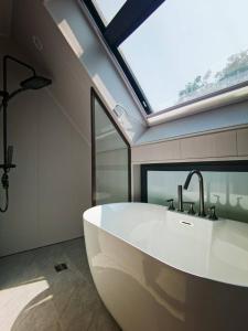 华阴Hua Shan Hidden Spring Exclusive Villa - Entire Private Property 隐泉禅境全栋私邸的一间带大型白色浴缸和窗户的浴室
