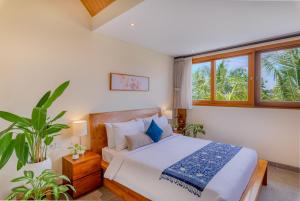 Un dormitorio con una cama y una ventana grande. en The Vinaya Boutique Hotel, en Ubud 85 fotos más