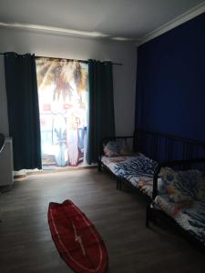 a bedroom with two beds and a surfboard on the floor at Macarena-AL in Almada