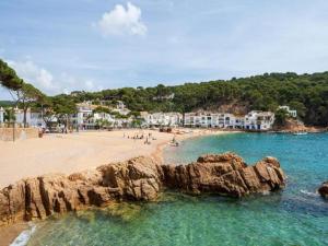 einen Strand mit Felsen im Wasser und Gebäuden in der Unterkunft Safari Tent in Begur near Costa Brava Beach in Fornells