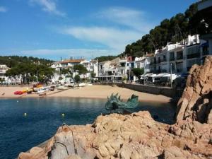 eine Statue am Strand mit Gebäuden in der Unterkunft Safari Tent in Begur near Costa Brava Beach in Fornells