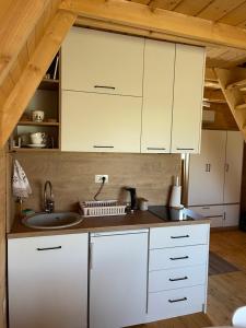a kitchen with white cabinets and a sink at Warm home 2 Zabljak in Žabljak